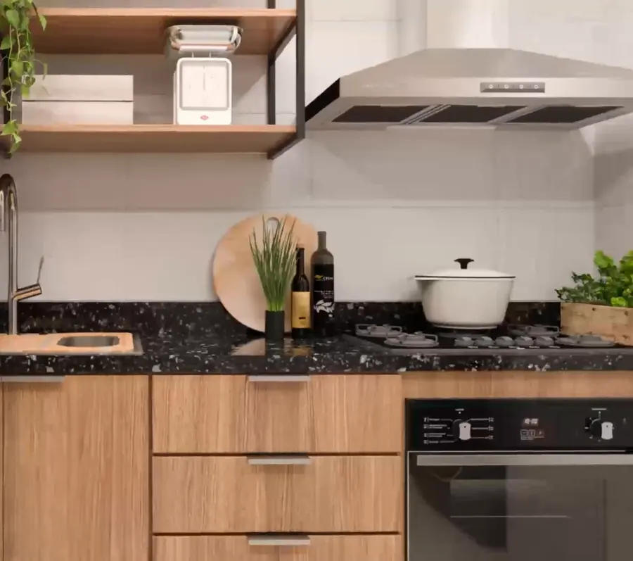 Cozinha de apartamento do Basílio Tijuca, com bancada em granito e armários em madeira